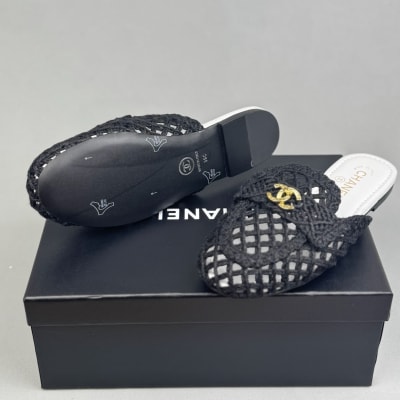 Chanel black mules feature a intricate woven design with gold-tone CC logos on the front