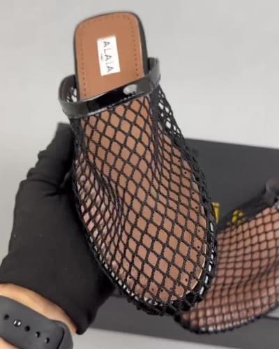 Alaïa black fishnet mules are flat slip-on — 5