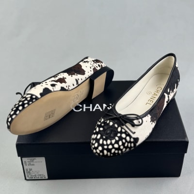 Chanel ballet flats feature a black and white cow print design