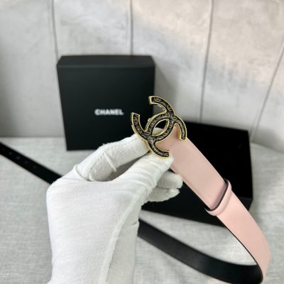Chanel belt features a pale pink leather strap paired with a distinct black and gold CC logo buckle — 5