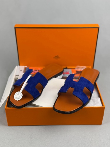 Hermès Oran sandals crafted from navy suede with the signature "H" cut-out