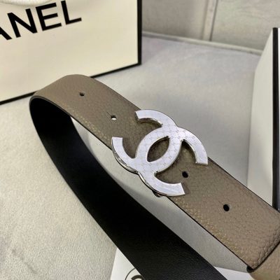 Chanel belt features a taupe-colored grained leather strap and a gold-tone "CC" logo buckle — 6