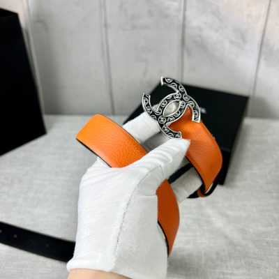 Chanel orange belt features a textured leather strap and a distinctive CC logo buckle — 7