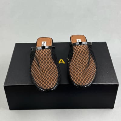 Alaïa black fishnet mules are flat slip-on — 3